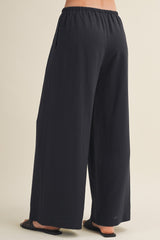 woman wearing black wide-leg pants with an elastic waistband, shown from the back