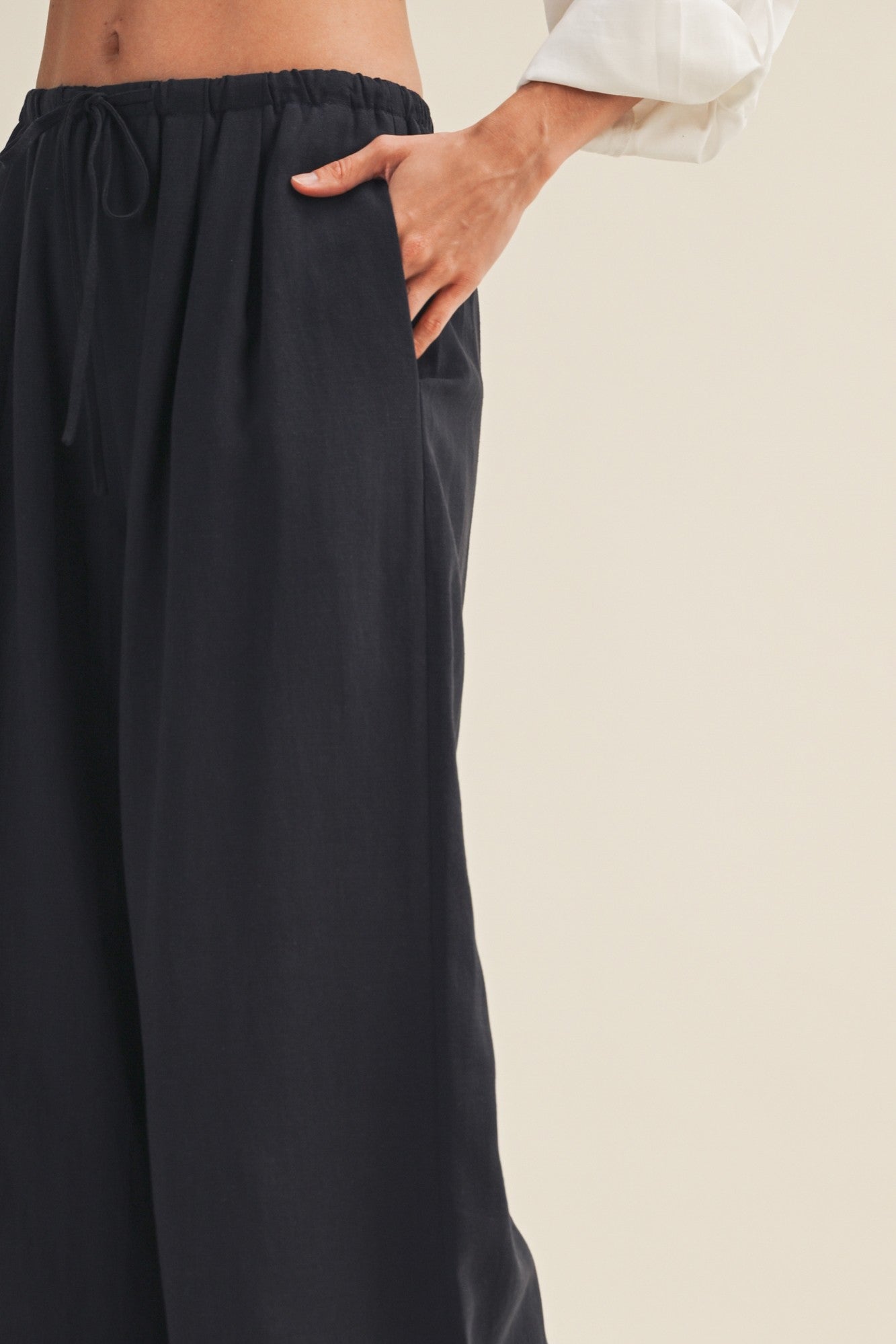 woman wearing black wide leg pants with an elastic waistband and side pockets