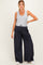 woman wearing a gray tank top and navy wide-leg maternity pants with a drawstring, standing with one hand on her hip