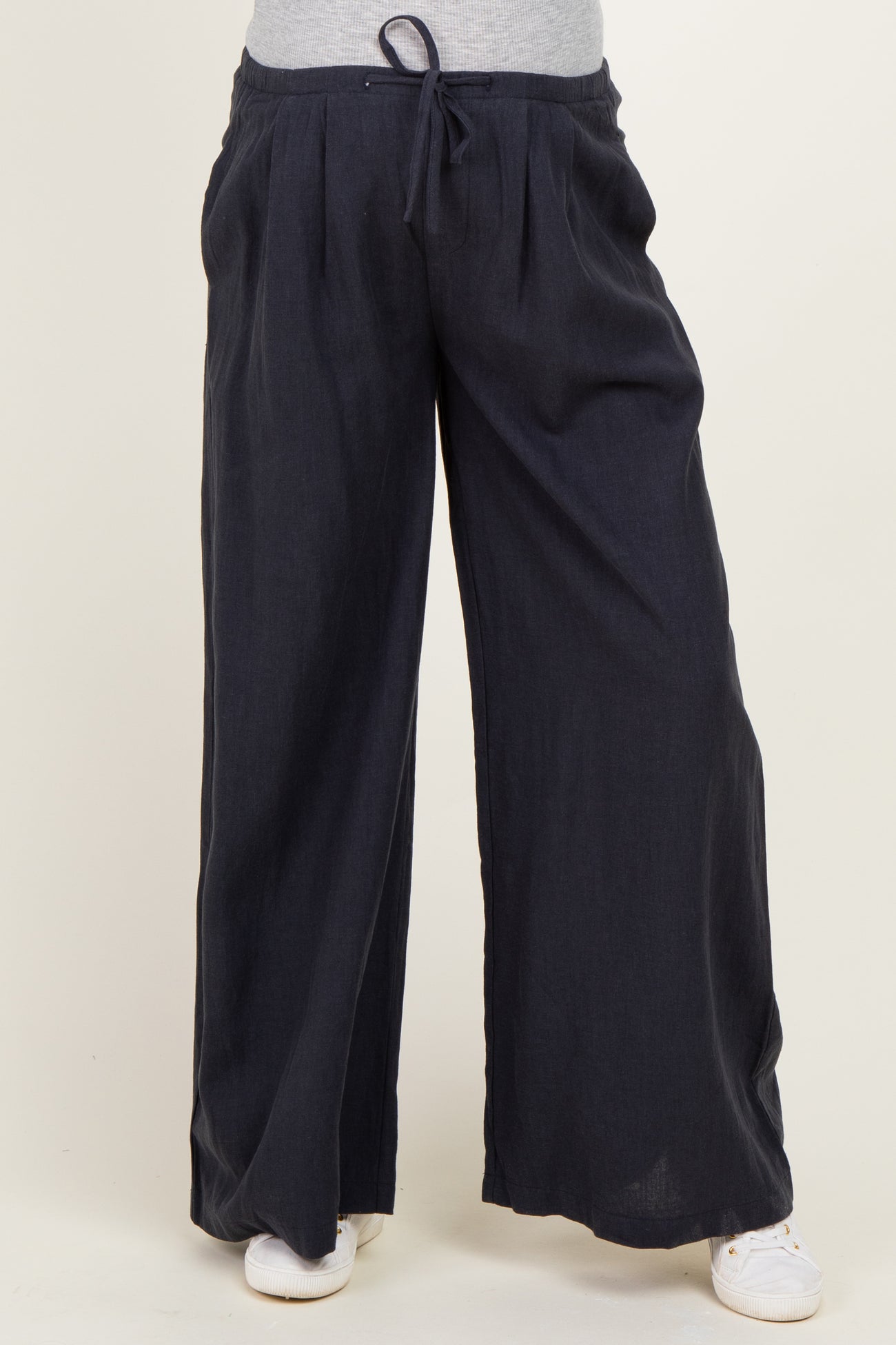 woman wearing dark navy wide-leg maternity pants with an elastic waistband and drawstring detail