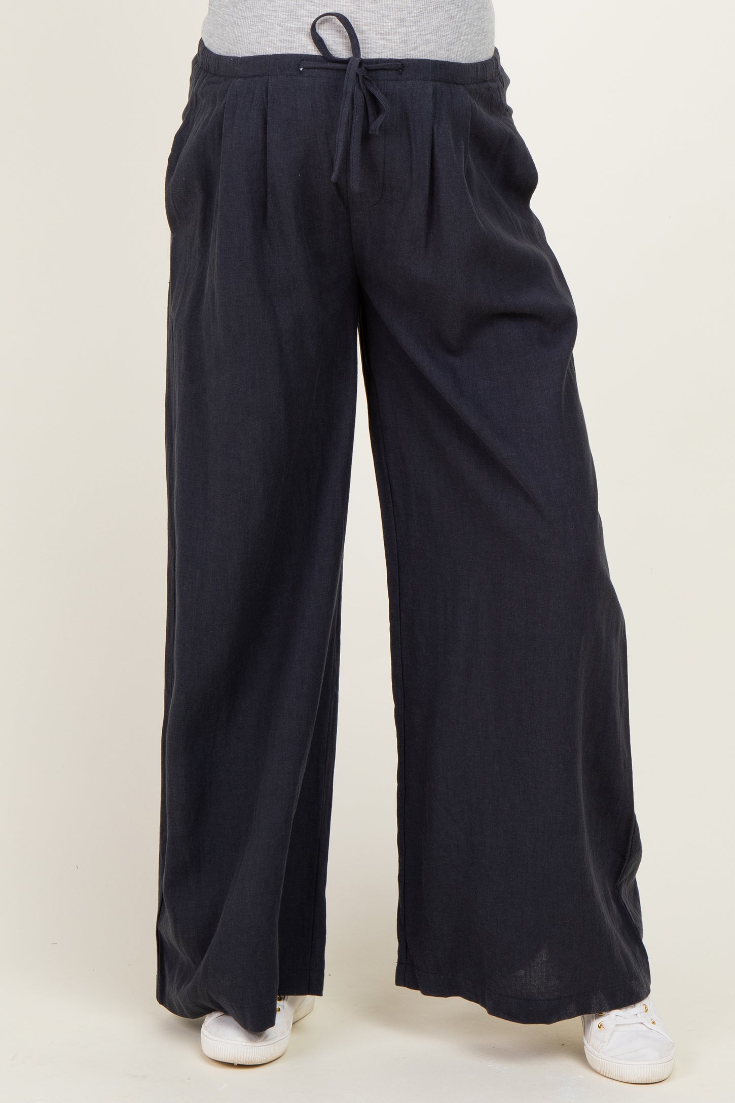 woman wearing dark navy wide-leg maternity pants with an elastic waistband and drawstring detail