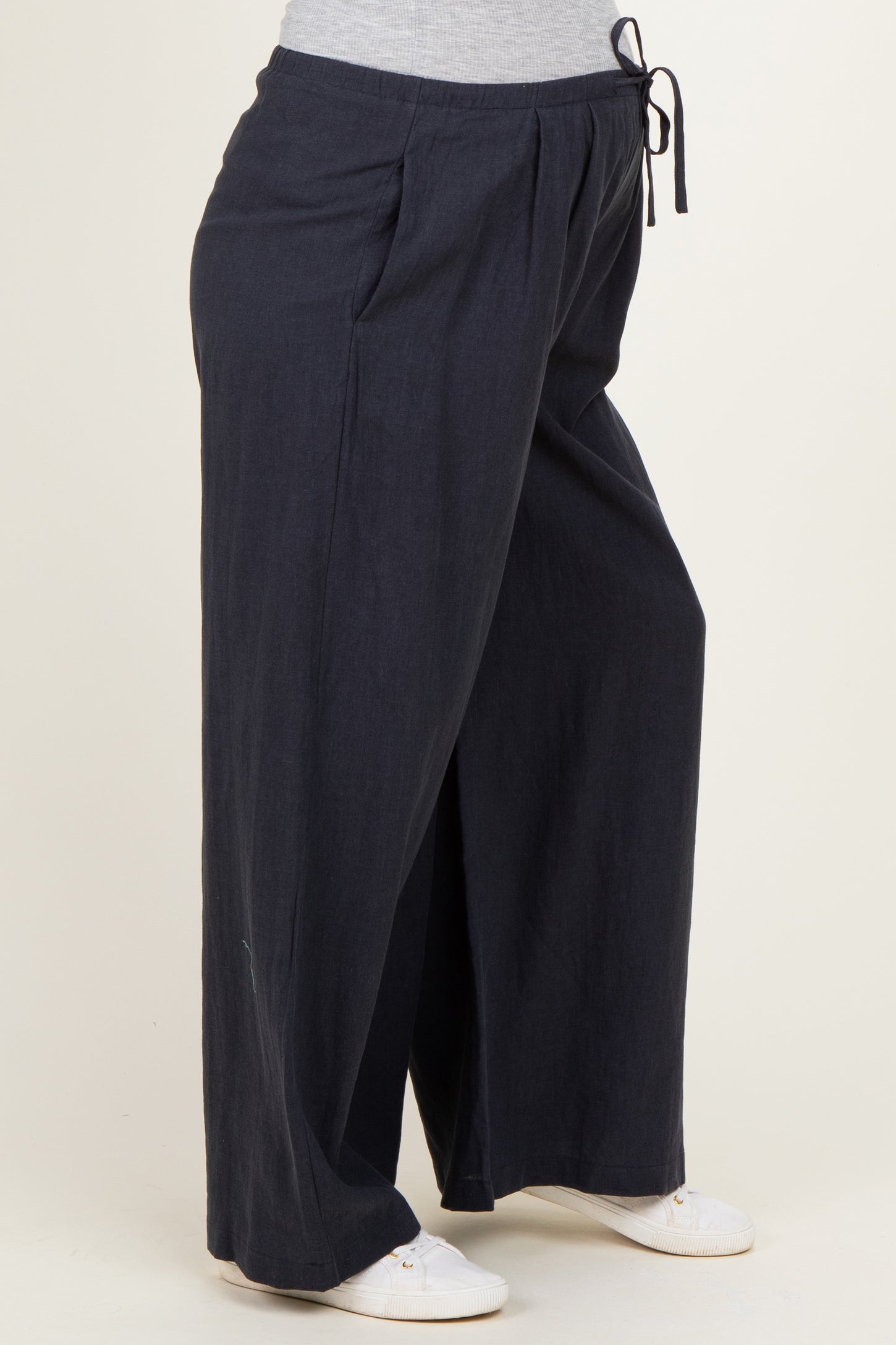 woman wearing navy blue maternity wide-leg pants with a drawstring waist and side pockets