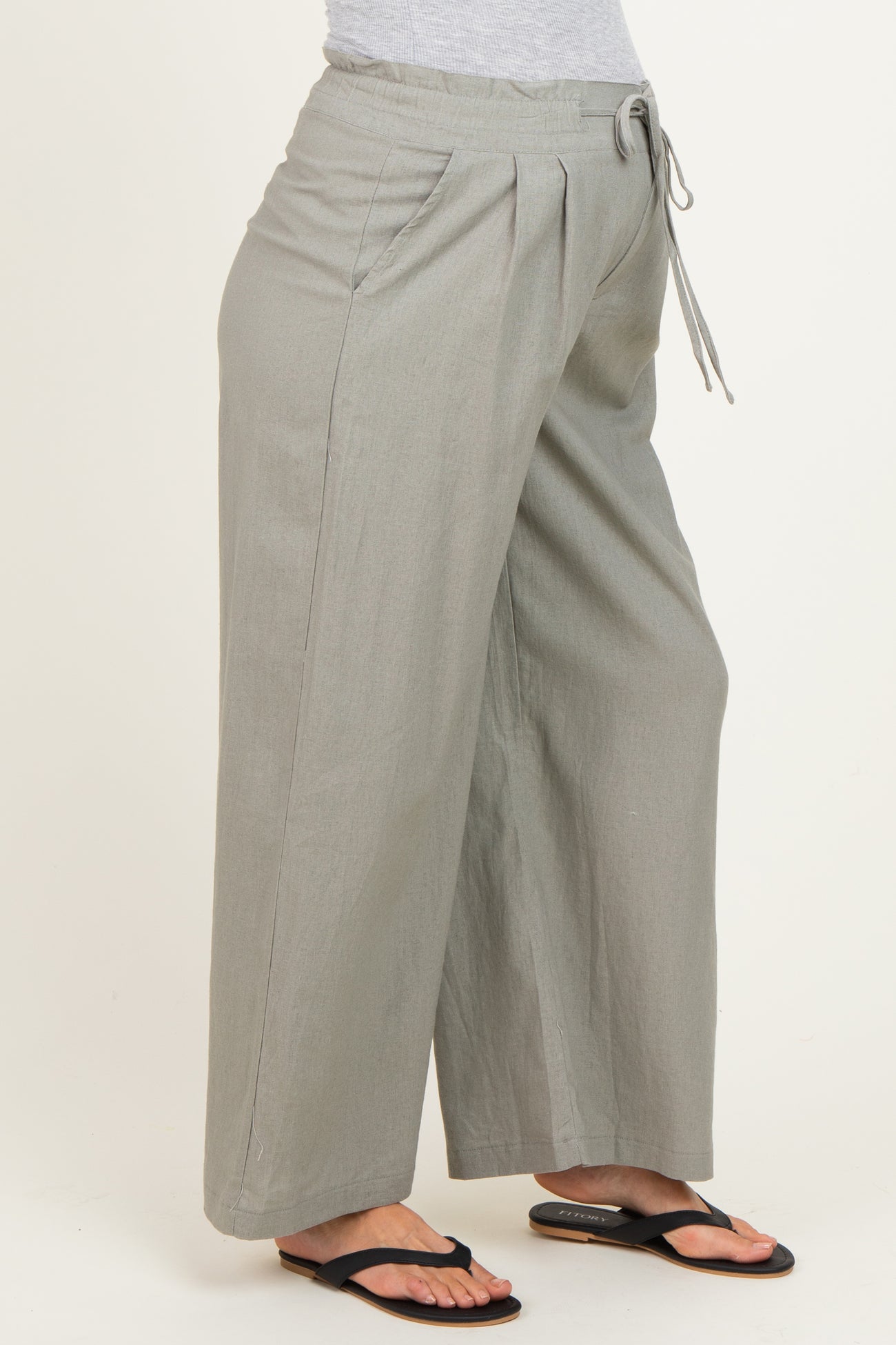 woman wearing light gray maternity wide-leg pants with a drawstring waist and side pockets