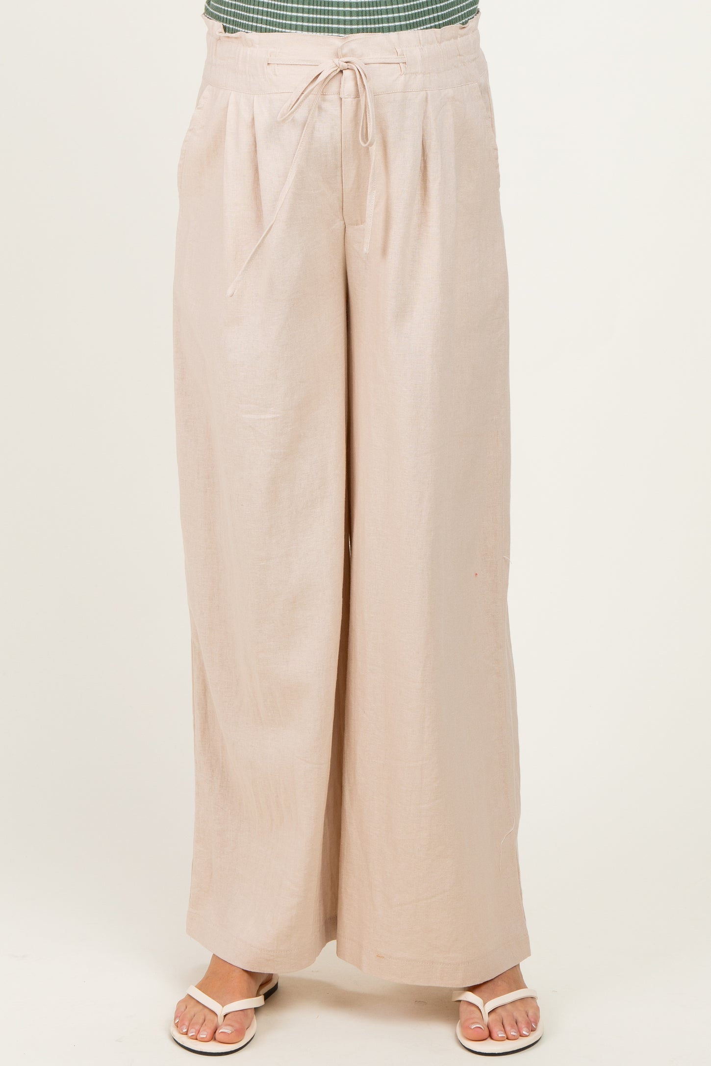 woman wearing light beige maternity wide-leg pants with tie waist detail