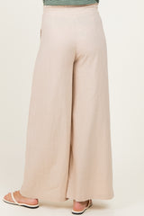 woman wearing light beige wide-leg maternity pants from the back, showing a relaxed fit and lightweight fabric
