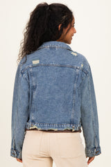 woman wearing a distressed light blue denim jacket, showcasing a relaxed fit and frayed hem, seen from the back