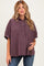 woman wearing a plum checkered maternity shirt with short sleeves and holding her baby bump