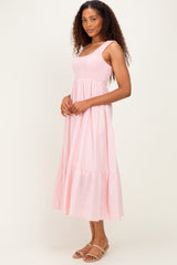 woman wearing a pink striped maxi dress with a fitted bodice and ruffled hem