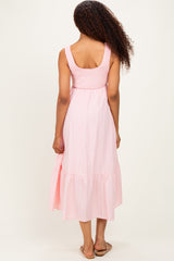 woman wearing a pink striped midi dress with a smocked bodice and tiered hem, shown from the back