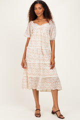 woman wearing a white floral tiered midi dress with puff sleeves and a ruffled hem