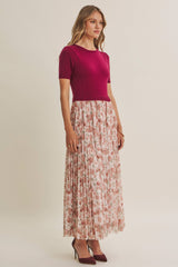 woman wearing a fuchsia short sleeve top and a floral pleated maxi skirt with heeled shoes