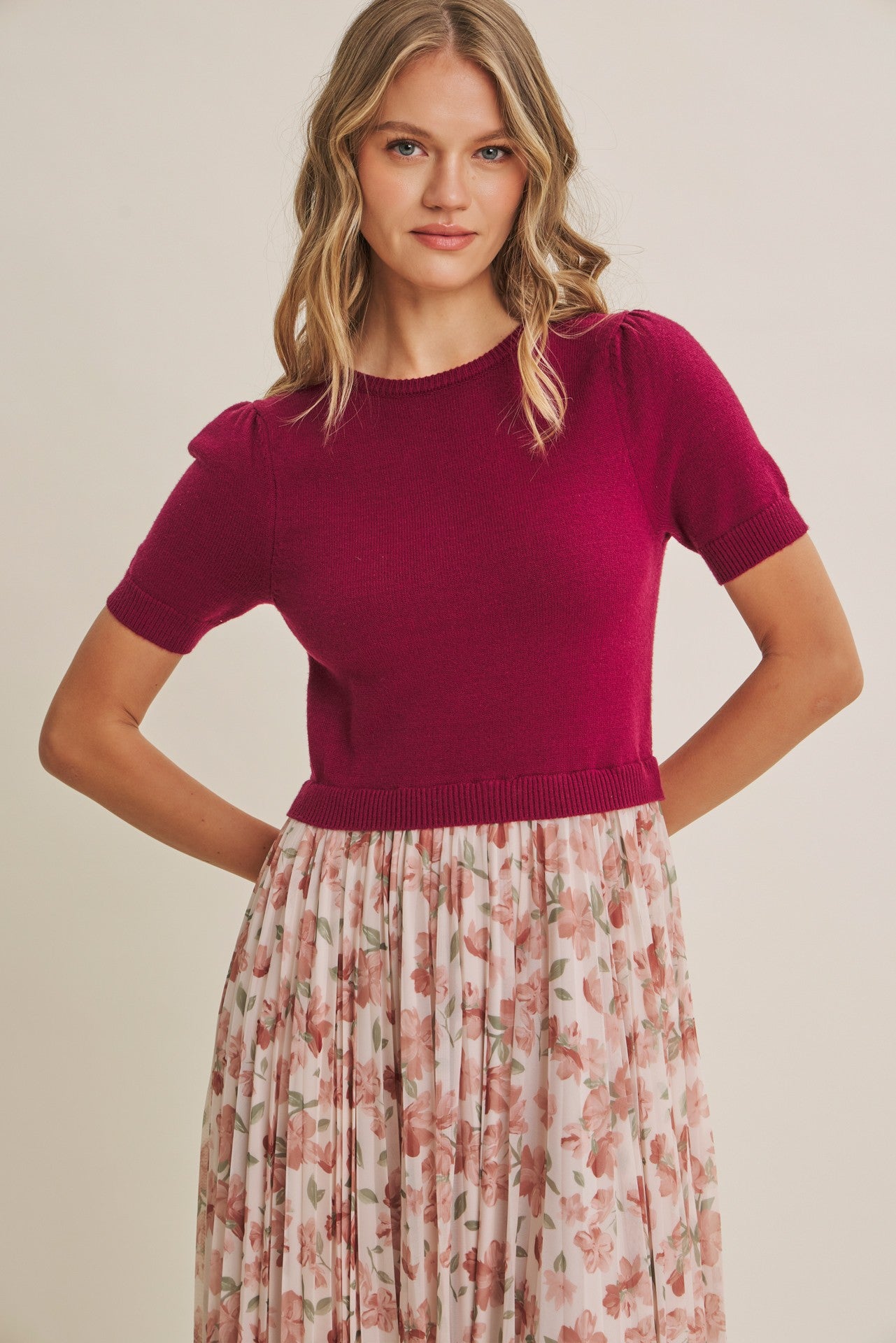 woman wearing a fuchsia short sleeve sweater styled with a floral maxi skirt