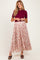 woman wearing a burgundy short sleeve top and a flowy floral maternity skirt with a pleated design