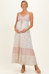 woman wearing a pink and white floral maternity maxi dress, showcasing her baby bump with a relaxed style
