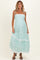 woman wearing a mint green floral maternity maxi dress with adjustable straps and ruffled hem