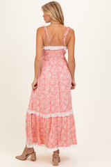 woman wearing a pink floral maternity maxi dress with adjustable straps and lace trim, showing the back view
