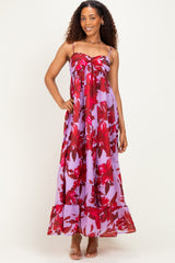 woman wearing a purple maxi dress with red floral prints and spaghetti straps