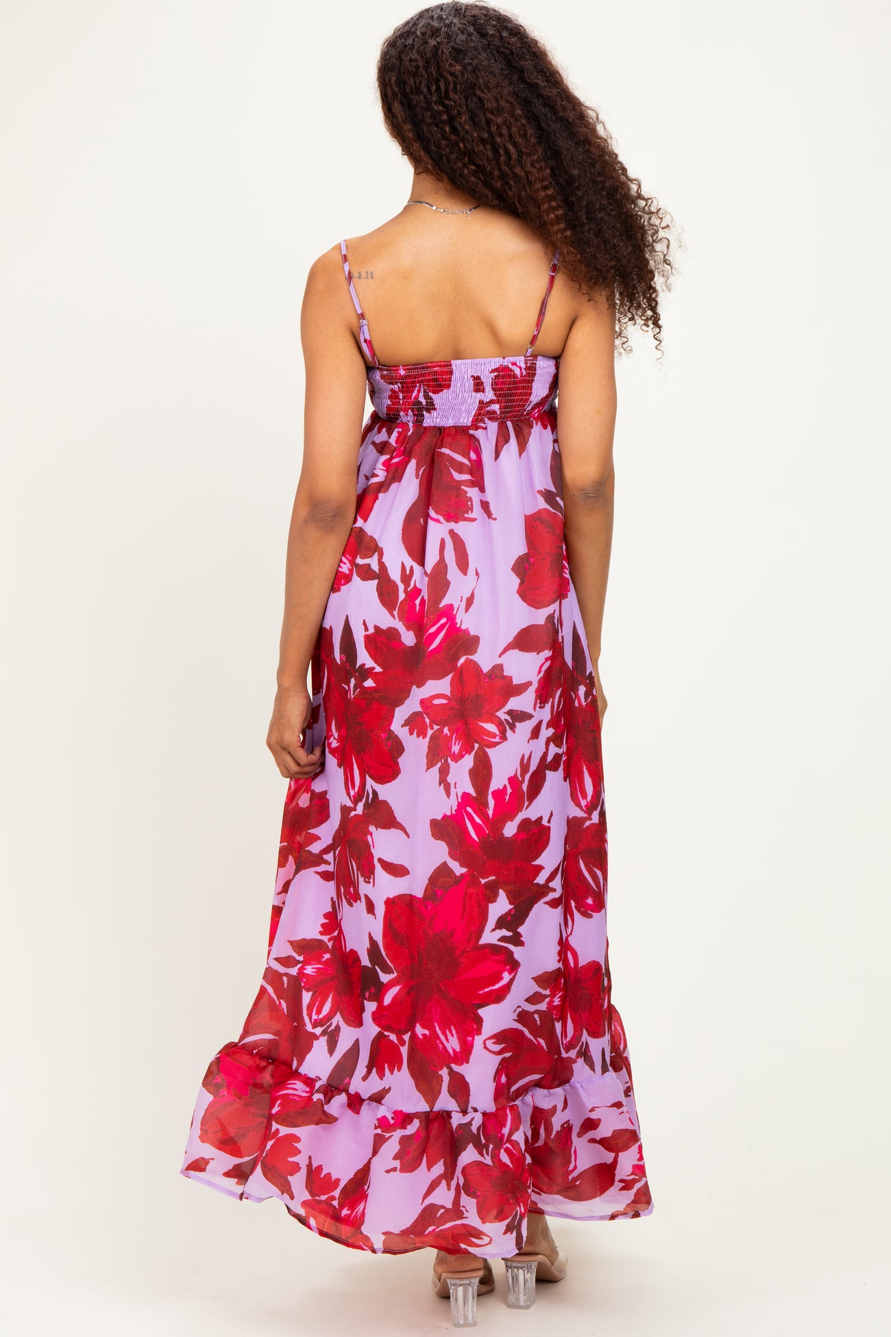 woman wearing a flowy light purple maxi dress with large red floral print and adjustable spaghetti straps