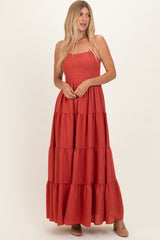 woman wearing a rust red tiered maxi dress with a square neckline and a flowy silhouette