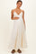 woman wearing a cream maternity maxi dress with a tiered design and holding her baby bump