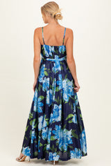 woman wearing a navy floral maternity maxi dress with thin straps and a flowing skirt, showcasing her baby bump