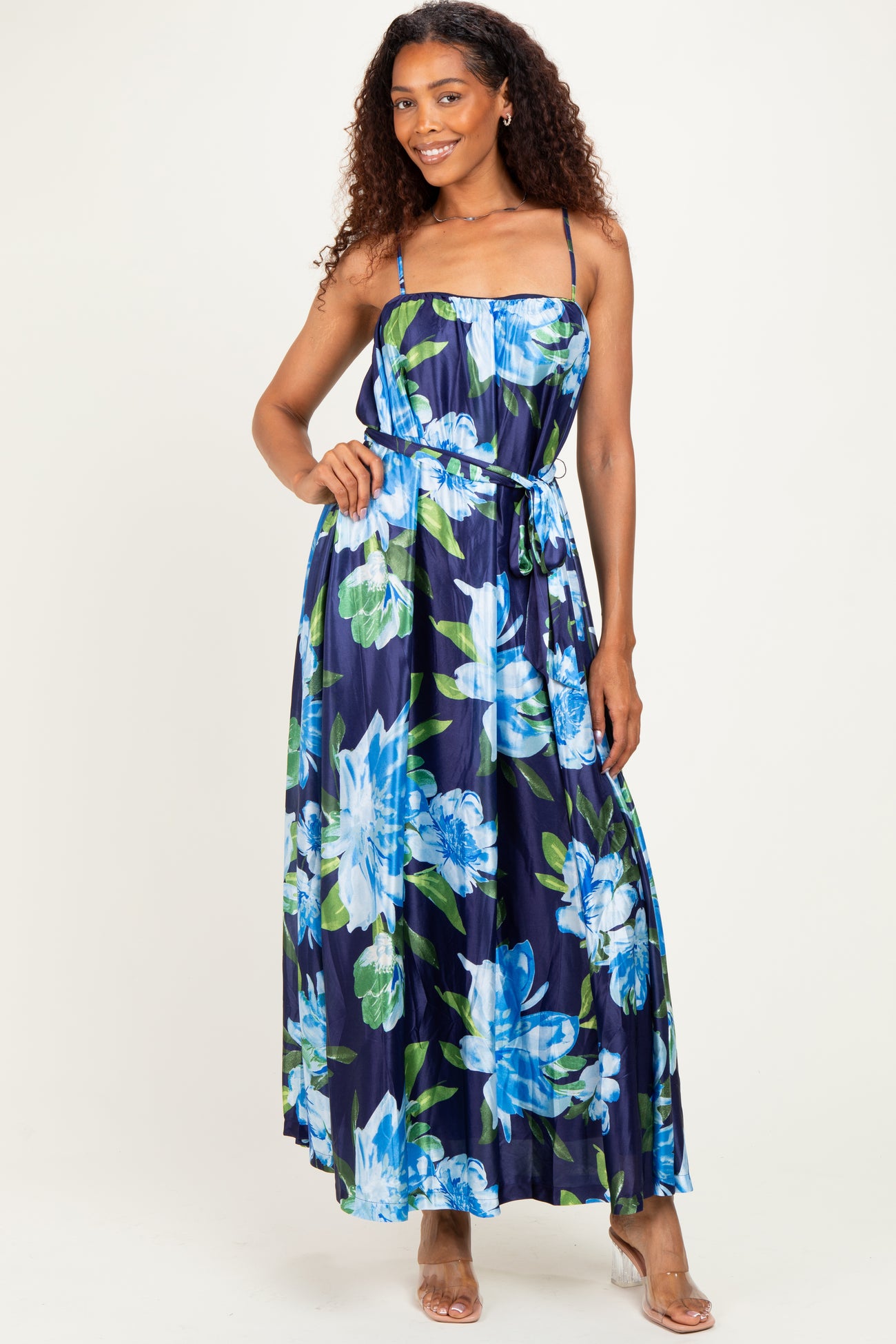 woman wearing a navy floral maxi dress with spaghetti straps and a tie waist detail