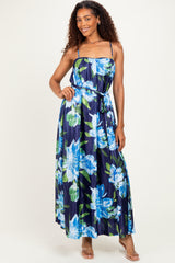 woman wearing a navy floral maxi dress with spaghetti straps and a tie waist detail