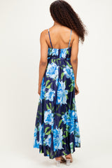 woman wearing a navy blue floral maxi dress with a flared skirt and spaghetti straps, viewed from the back
