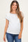 woman wearing a white maternity top with black trim and a subtle pocket, paired with blue jeans and showing a baby bump
