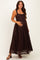 woman wearing a dark brown lace maternity dress and holding her baby bump