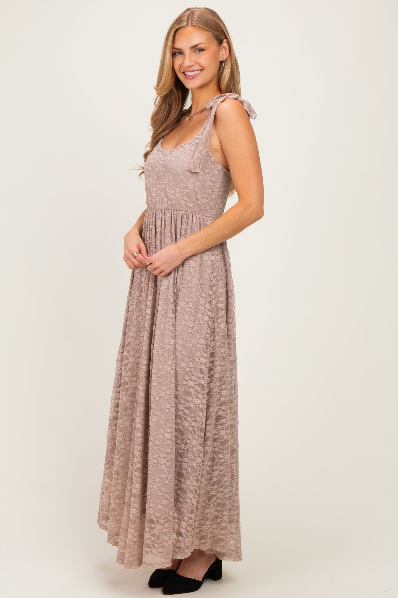 woman wearing a mauve sleeveless maxi dress with tie shoulder straps and a flowing skirt