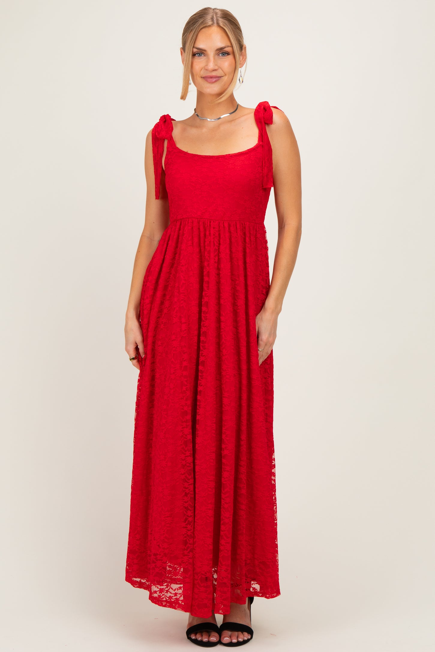 woman wearing a red maxi dress with tie shoulder straps and a loose fit
