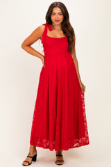 woman wearing a red lace maternity maxi dress with a square neckline and adjustable straps, showing her baby bump