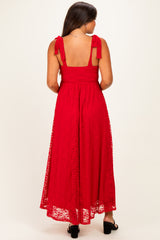 woman wearing a red lace maternity maxi dress with tie shoulder straps, showing a baby bump from the back