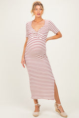 woman wearing a striped maternity dress with a twist front and side slits, showcasing her baby bump