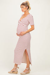 woman wearing a striped maternity dress with a twist front and side slit, showcasing her baby bump