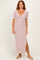 woman wearing a striped midi dress with a twisted front detail and side slit, standing on a neutral background