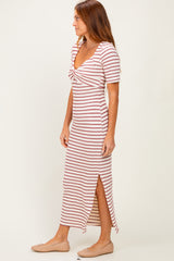 woman wearing a striped midi dress with a knotted front and side slit, paired with flat shoes