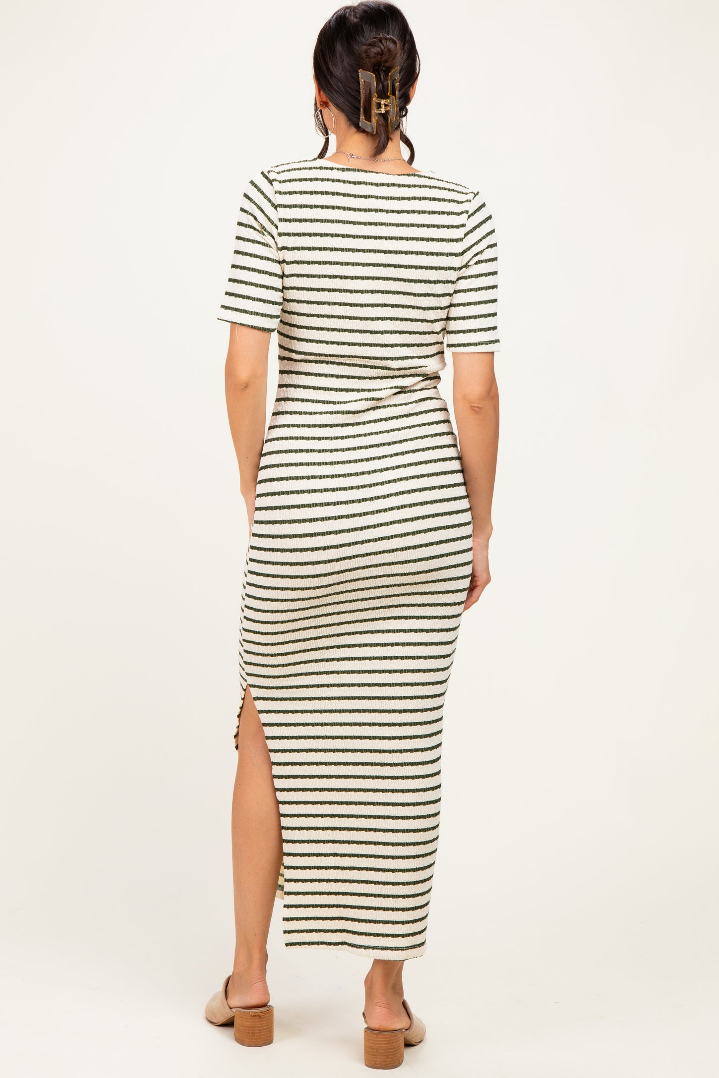 woman wearing a striped maxi dress with short sleeves and a side slit, shown from the back