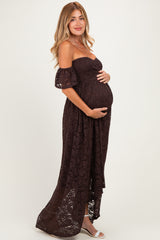 woman wearing a dark brown lace off-shoulder maternity dress and holding her baby bump