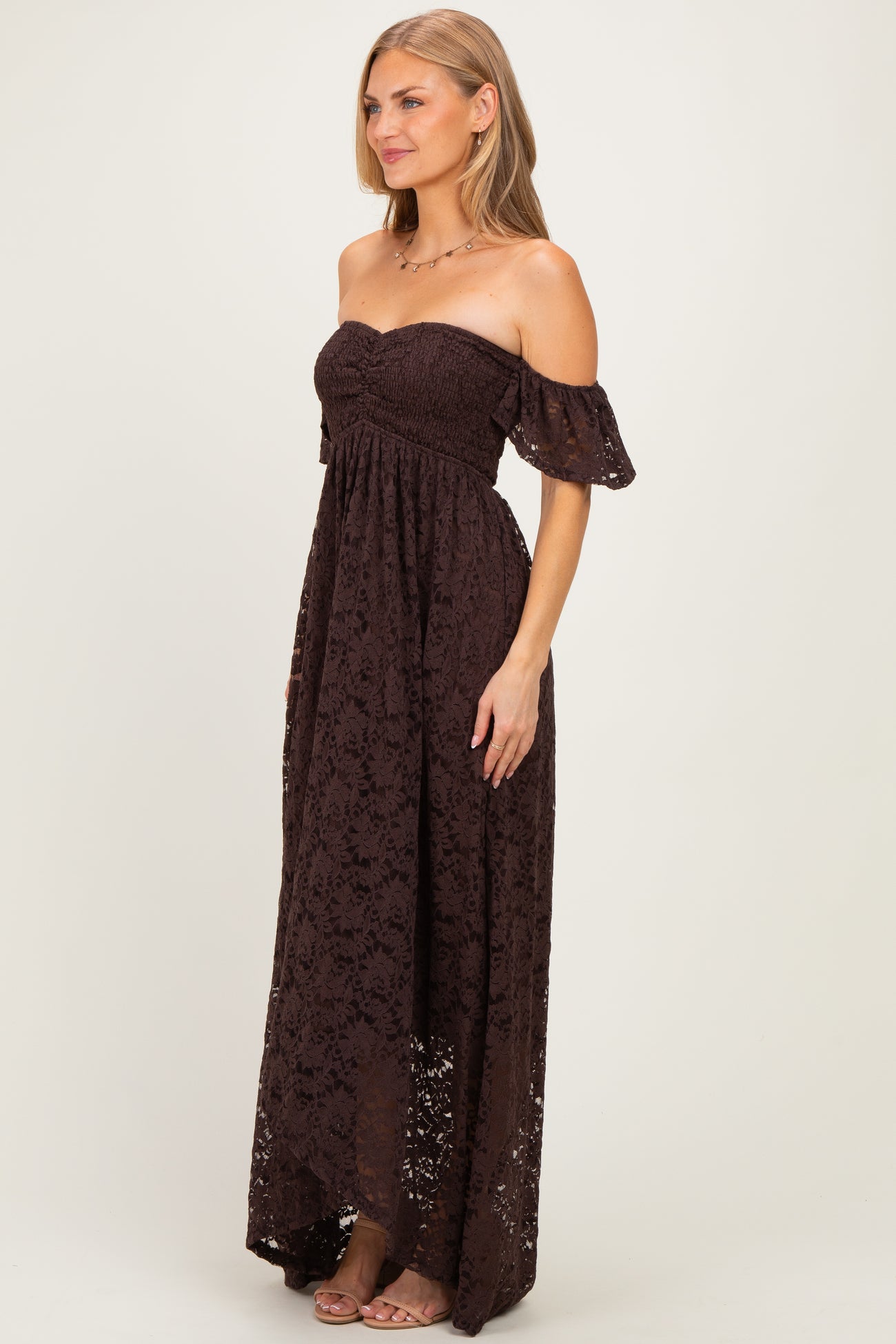woman wearing a dark brown off-the-shoulder maxi dress with lace detailing and a smocked bodice