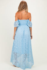 woman wearing a light blue lace off-shoulder maternity dress with puff sleeves and a flowing maxi length