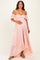 woman wearing a light pink off-the-shoulder lace maternity dress and holding her baby bump