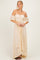 woman wearing a cream off-the-shoulder lace maxi dress with a ruched bodice and high-low hemline