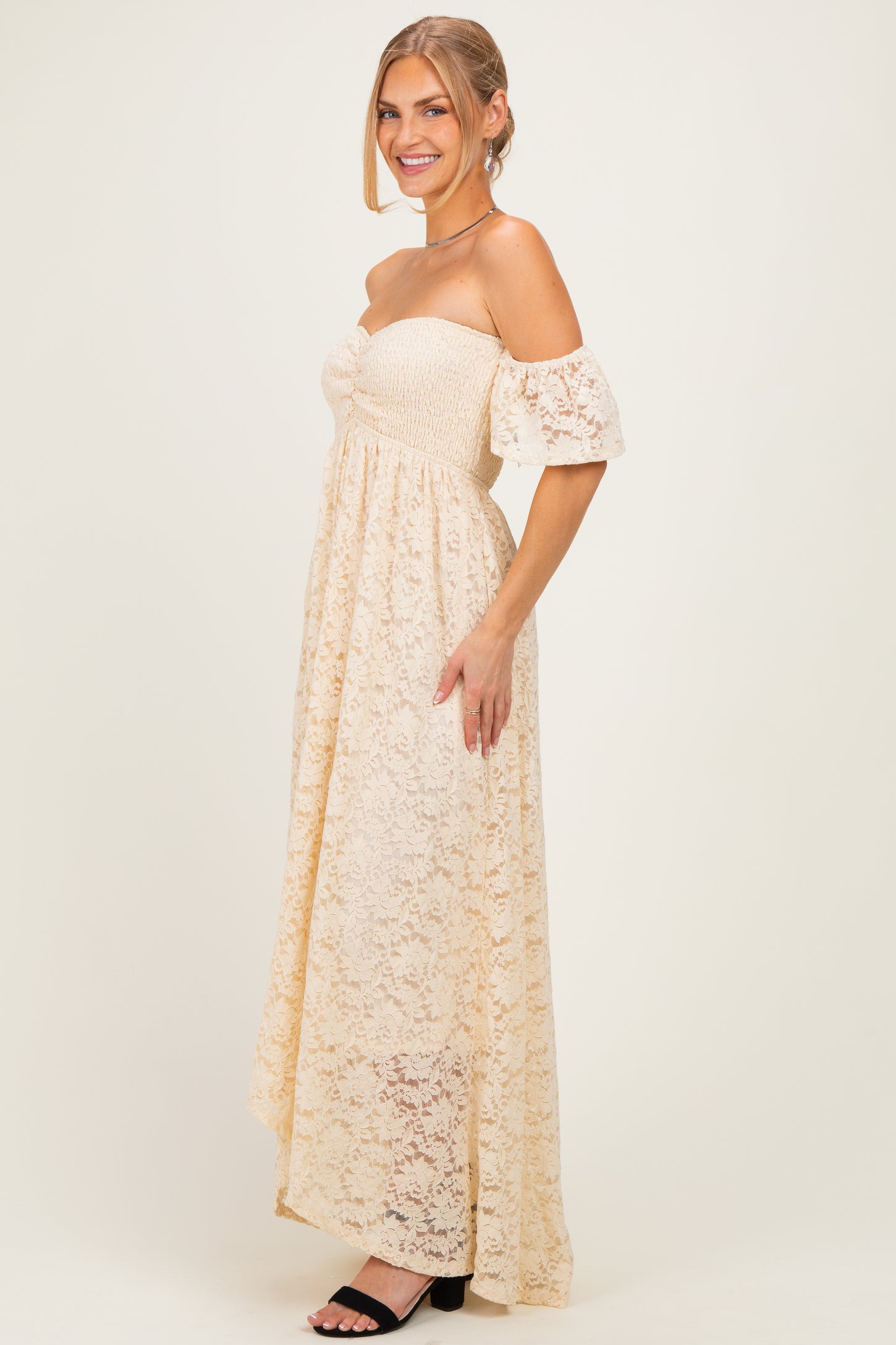 woman wearing a cream off-the-shoulder lace maxi dress with puff sleeves and a smocked bodice
