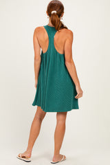 woman wearing a teal ribbed sleeveless dress with a back cutout design and a relaxed fit