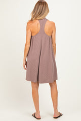 woman wearing a striped brown maternity dress with a halter neckline and open back