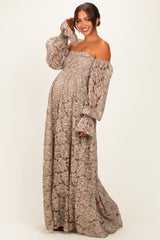 woman wearing a beige lace off-the-shoulder maternity gown with bell sleeves and a visible baby bump