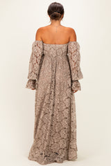 woman wearing a beige lace off-shoulder maternity dress with long sleeves and a loose fit, showing her back