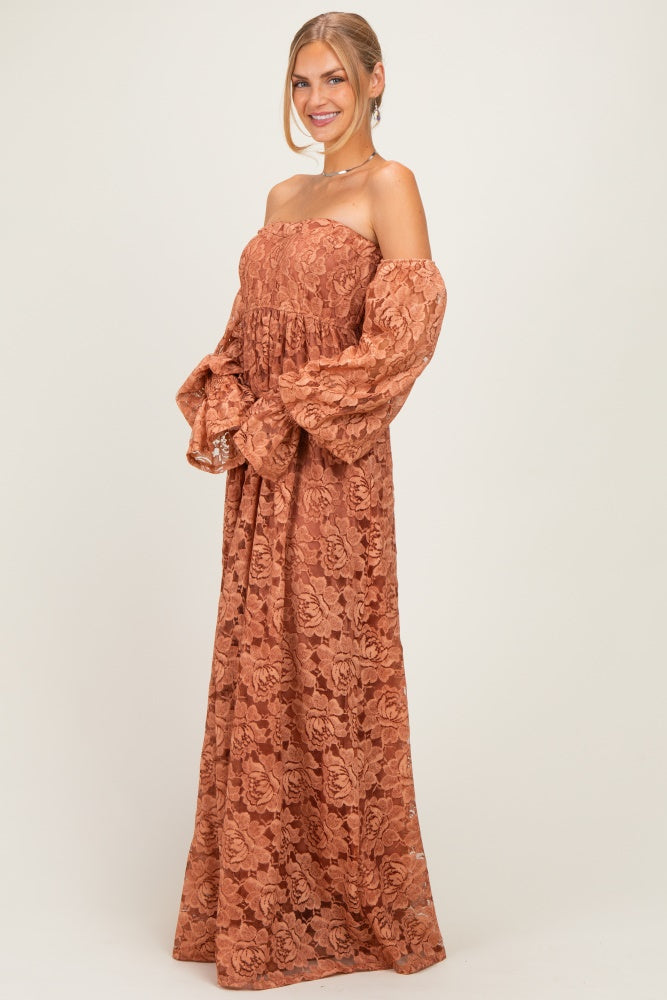 woman wearing a rust-colored off-shoulder maxi dress with puff sleeves and floral lace details